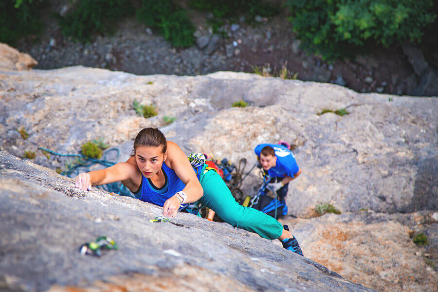Two people doing mountain sports with the proper safety equipment