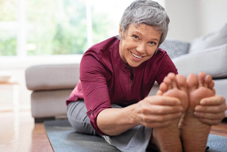 An older woman using exercise to reduce her feelings of stress during quarantine