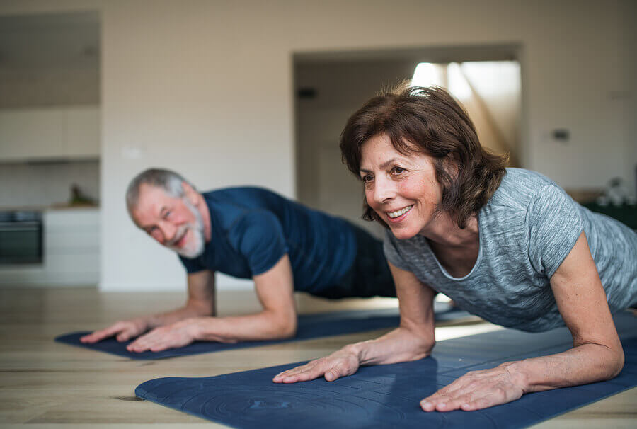 Two older people working out at home to maintain muscle mass during quarantine