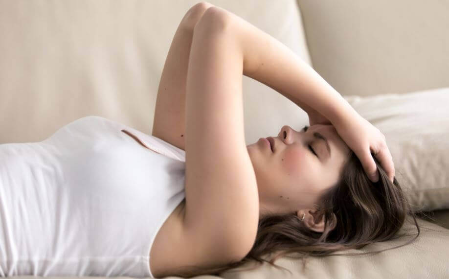 A woman who suffers from depression and anxiety lying on her bed