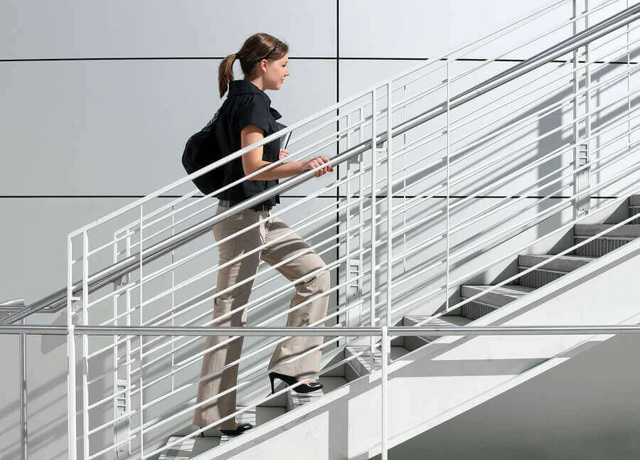 A woman using the stairs on her way to work to maintain muscle mass during quarantine