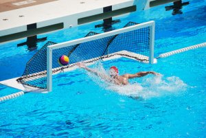 A goalkeeper failing to stop a shot in water polo.