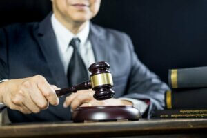 A judge banging their gavel to resolve legal disputes in sport.