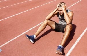 A runner sitting on the track suffering from depression in athletes.