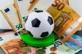 A toy soccer ball surrounded by money, which is one of the main legal aspects of being a professional athlete.