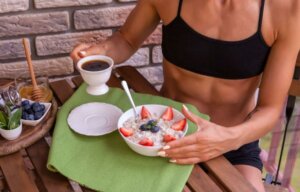 A woman eating oatmeal with coffee.