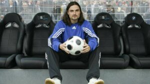 Lutz Pfannenstiel sitting down and holding a soccer ball.