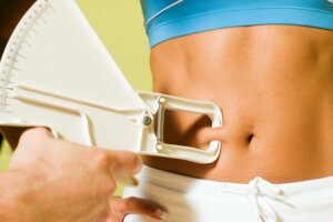 Someone having their belly fat measured.
