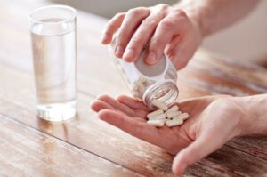 Someone tipping glutamine pills into their hand.