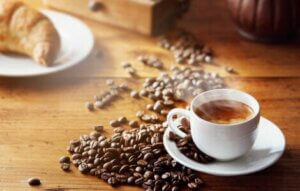 A cup of espresso surrounded by coffee beans.