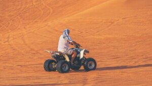 A man on a quadbike in the desert.