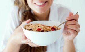 A woman eating a bowl of cereal.