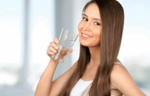 A woman with a glass of water before snacking between meals.