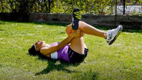 A woman using one of her legs to stretch out the other one