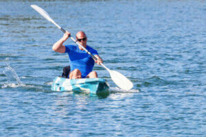 A man canoeing in open waters.
