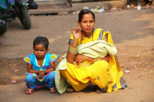 A mother and child squatting in the st.