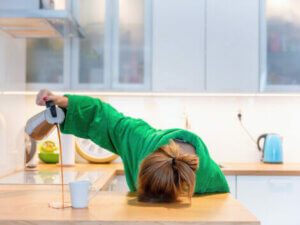A tired woman pouring a cup of coffee.