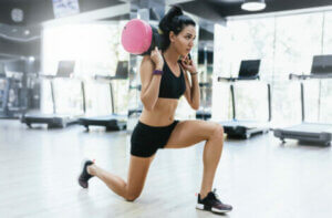 A woman doing a sandbag lunge.