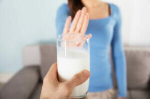A woman rejecting a glass of milk.