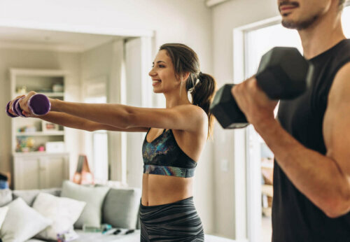 Man and woman lifting weights at home.