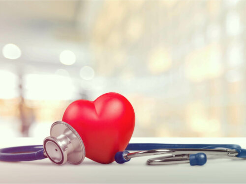 A heart on a table next to a stethoscope.