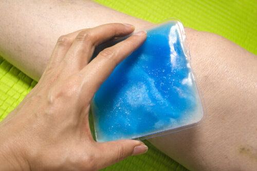 An individual applying a cold compress on their arm.