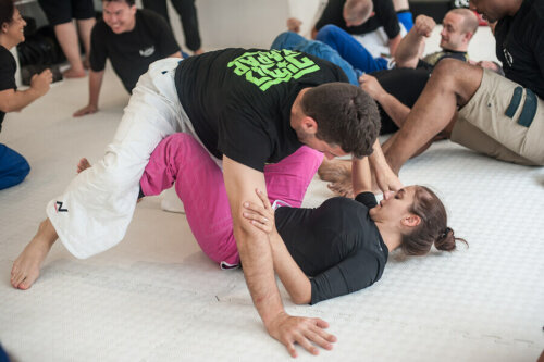 A jiu-jitsu trainer working with a student.