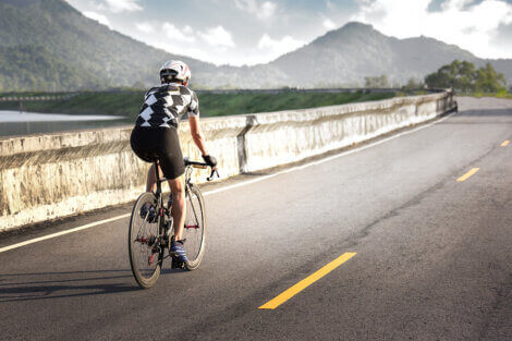 A man riding a bike while listening to music to increase his sports performance