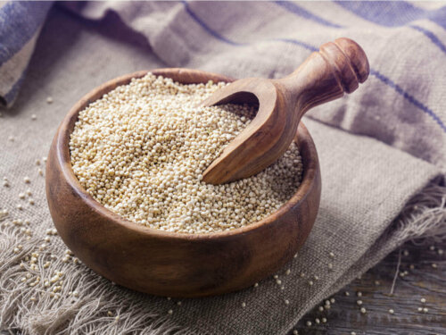 A wooden bowl filled with dry quinoa.