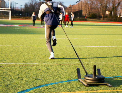A man carrying out a sled drag.