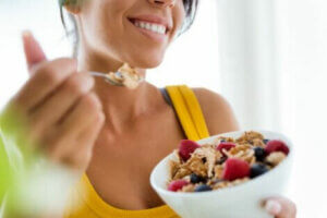 A woman eating a bowl of cereal.