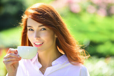 A woman drinking her first daily cup of green coffee