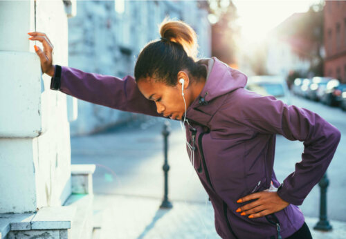 Woman leaning on a wall, tired from running.