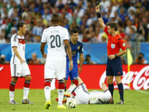 A referee holding up a yellow card.