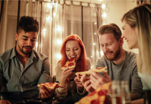 A group of friends eating pizza at dinner.