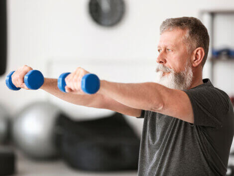 An older man lifting dumbbells.