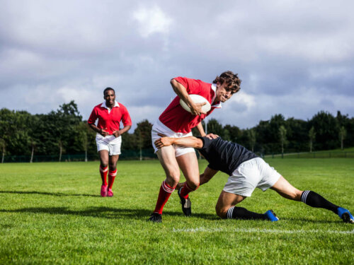 Rugby players tackling.