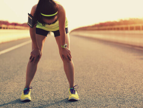 A woman suffering from muscle fatigue after running