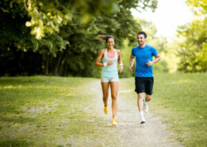 A man and woman running through the park.