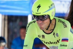 A man cycling after just drinking an isotonic sports drink.