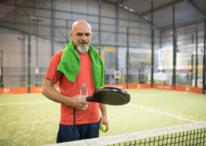 A man standing on a padel tennis court.
