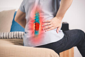 A person sitting down with back pain.