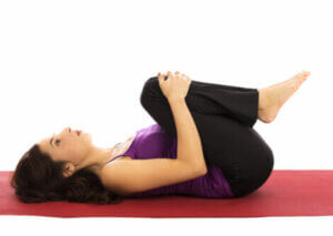A woman stretching on the floor.