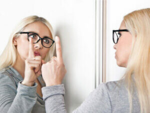 A woman talking to herself in the mirror.