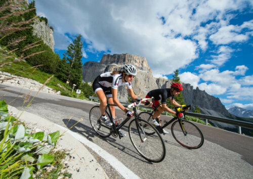 A men and a woman cycling on a curve.