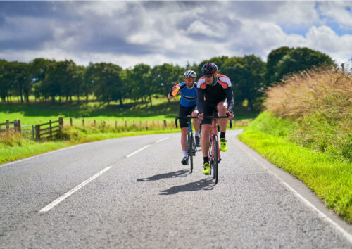 Two men riding a bike in the mountains.