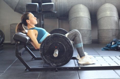 Women lifting weights on a bar.