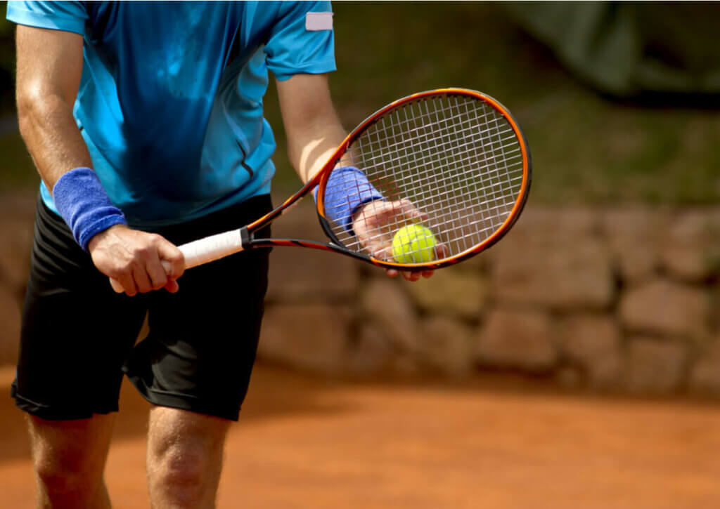tennis player preparing to serve; paddle tennis and tennis