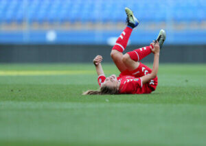 A soccer player suffering an injury on the field.