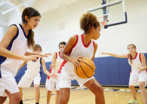 Teenagers playing basketball.